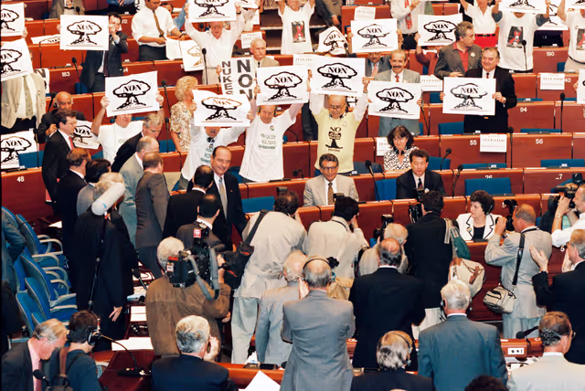 Fotagrafa 12: In July 1995, during an official visit to the EP in Strasbourg, Jacques CHIRAC, President of the French Republic, faced a demonstration in front of EP building and a strong opposition among MEPs against decision taken by France to resume nuclear testing in Moruroa.