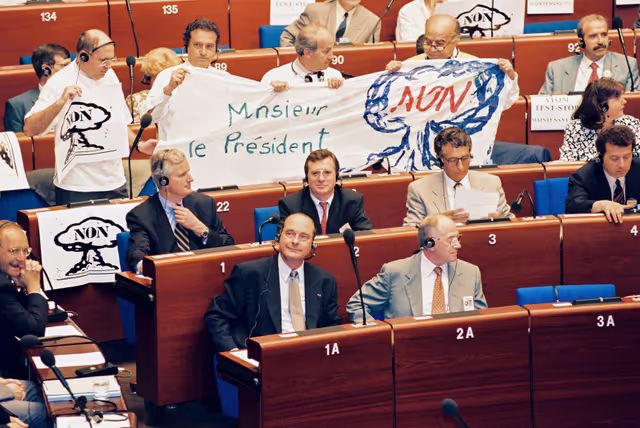 Fotagrafa 7: In July 1995, during an official visit to the EP in Strasbourg, Jacques CHIRAC, President of the French Republic, faced a demonstration in front of EP building and a strong opposition among MEPs against decision taken by France to resume nuclear testing in Moruroa.