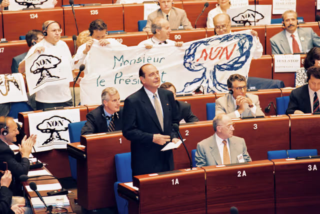 Fotagrafa 14: In July 1995, during an official visit to the EP in Strasbourg, Jacques CHIRAC, President of the French Republic, faced a demonstration in front of EP building and a strong opposition among MEPs against decision taken by France to resume nuclear testing in Moruroa.