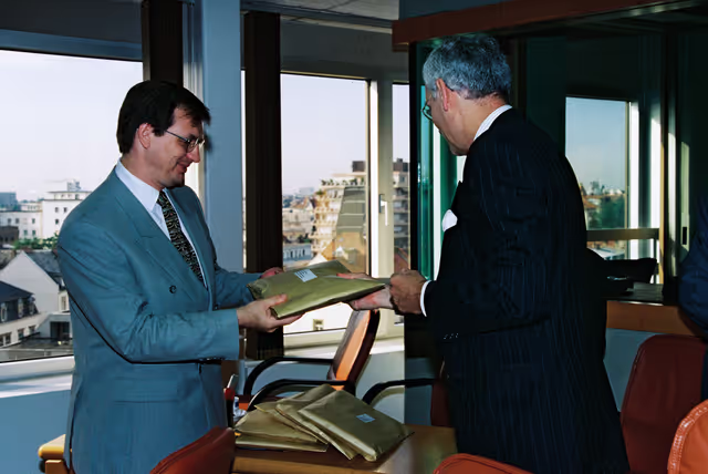 Commissioner Hans van den BROEK hands over an issue of the Agenda 2000