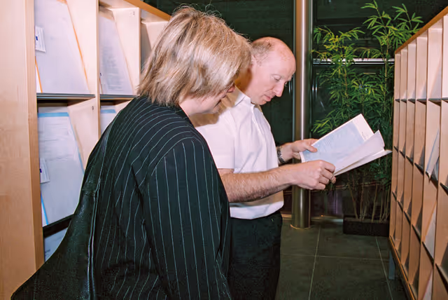 Foto 21: People consulting documents at the Infopoint