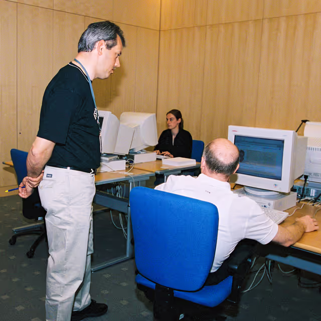 Foto 17: People consulting documents at the Infopoint