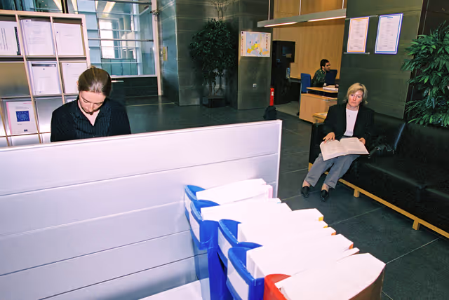 Foto 22: People consulting documents at the Infopoint