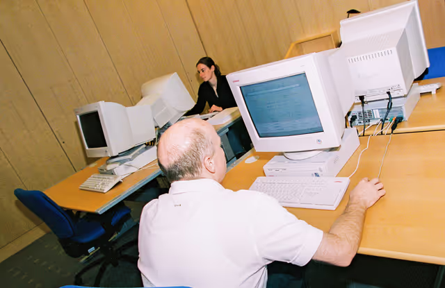 Foto 20: People consulting documents at the Infopoint