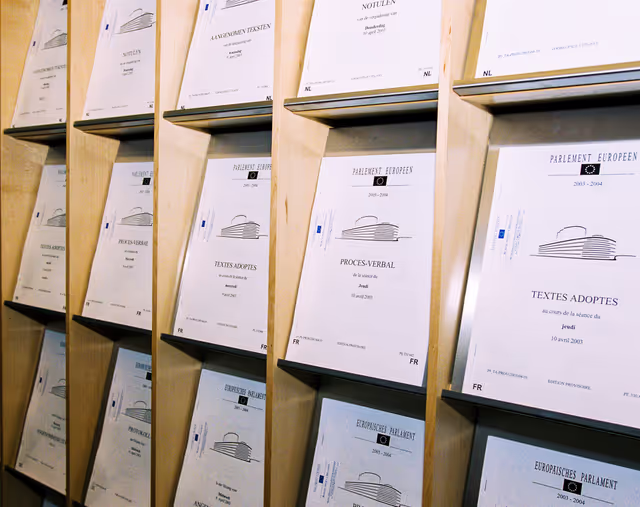 Foto 16: People consulting documents at the Infopoint