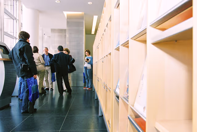 Foto 14: People consulting documents at the Infopoint