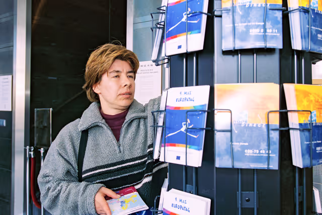 Foto 13: People consulting documents at the Infopoint