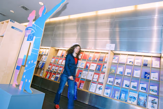 Foto 6: People consulting documents at the Infopoint