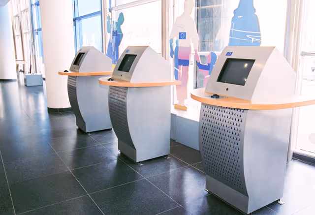 Foto 4: People consulting documents at the Infopoint