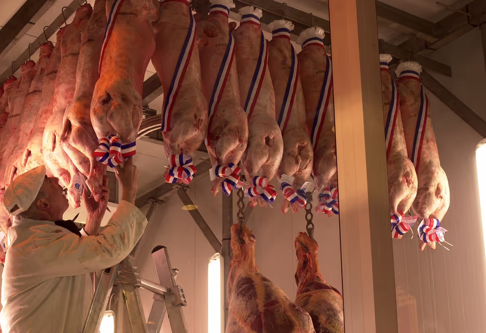 A man gets slaughtered porks labelled with a french flag