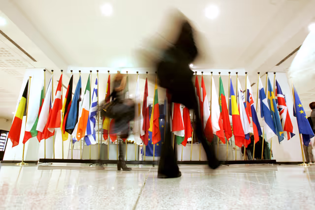 Photo 25: People walking in front of the flags of the EU member states at the EP in Brussels.