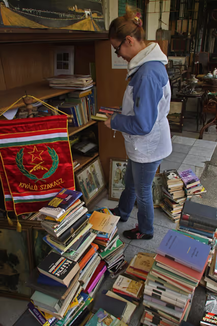 Photo 2: A hungarian costumer reads old books in the Budapest oldest junk and antiques market Ecseri